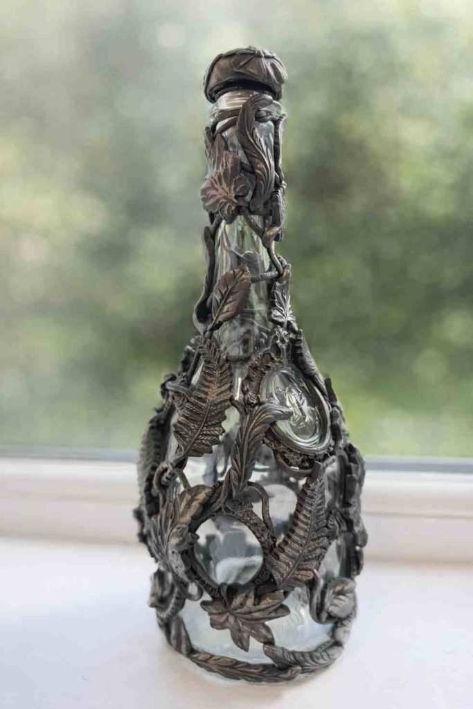 large wine bottle dressed in bronze effect leaves and vines from polymer clay