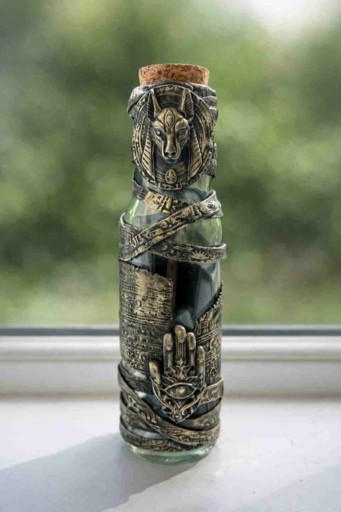 Egyptian themed tall glass jar wrapped in Egyptian stamped polymer clay sheath and Egyptian motiffs