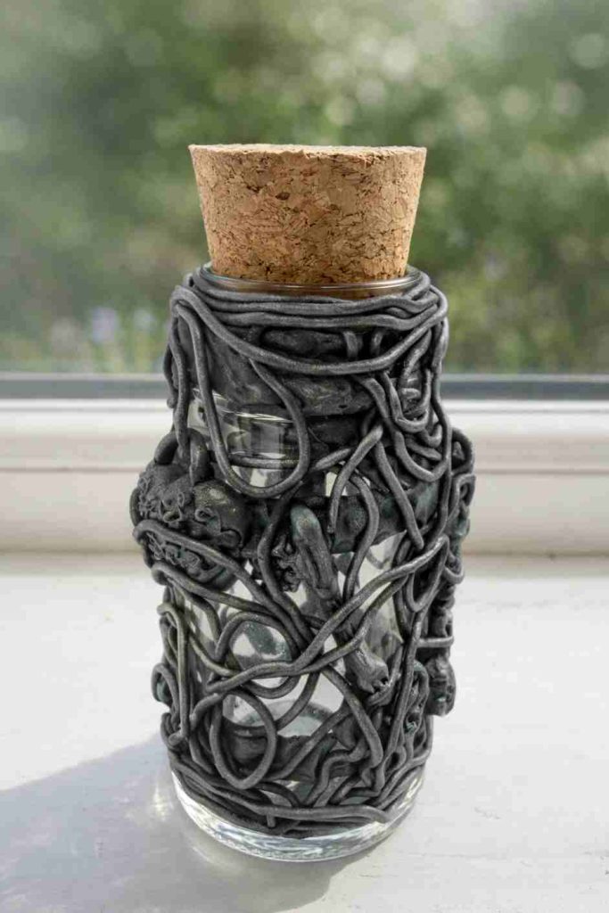 small spice jar dressed in polymer clay wire and lock and key motifs